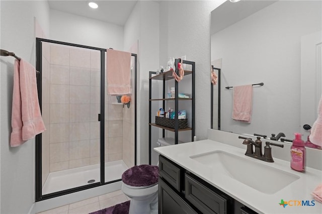 bathroom with tile patterned floors, toilet, vanity, and an enclosed shower