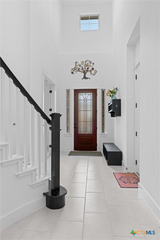 1604 Hinterwald St, Leander, TX 78641 - entryway with stairway, a towering ceiling, baseboards, and tile patterned flooring