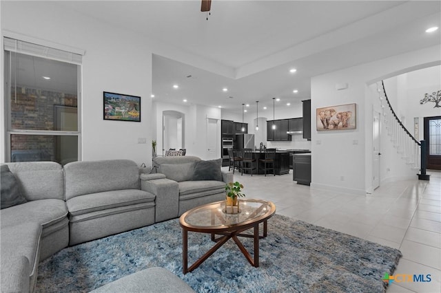 1604 Hinterwald St, Leander, TX 78641 - living room featuring arched walkways, stairs, light tile patterned floors, recessed lighting, and baseboards
