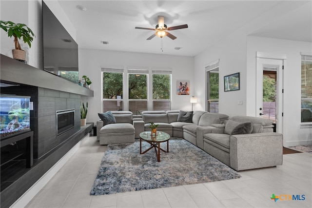 living room featuring a fireplace and ceiling fan