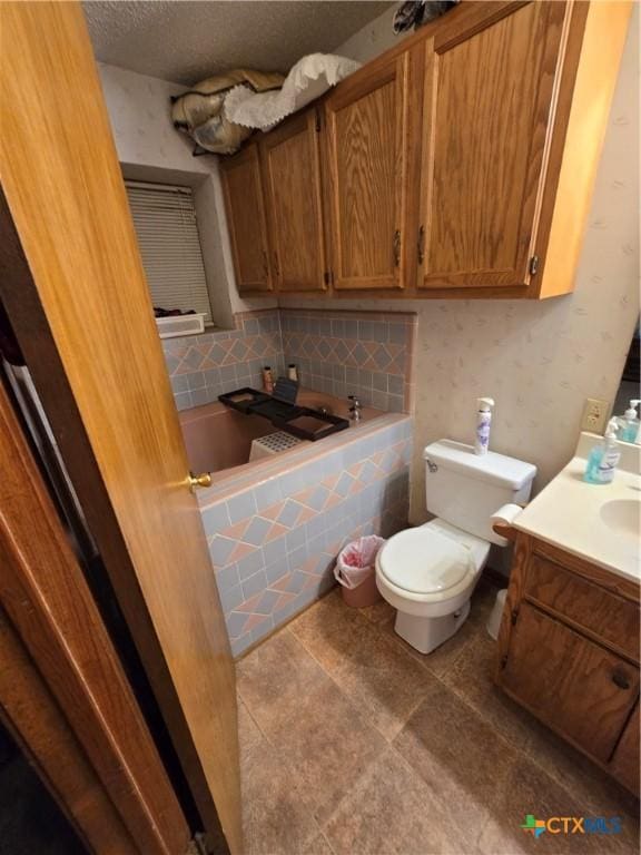 612 S 1st St, Copperas Cove, TX 76522 - full bathroom featuring a relaxing tiled tub, vanity, and a textured ceiling