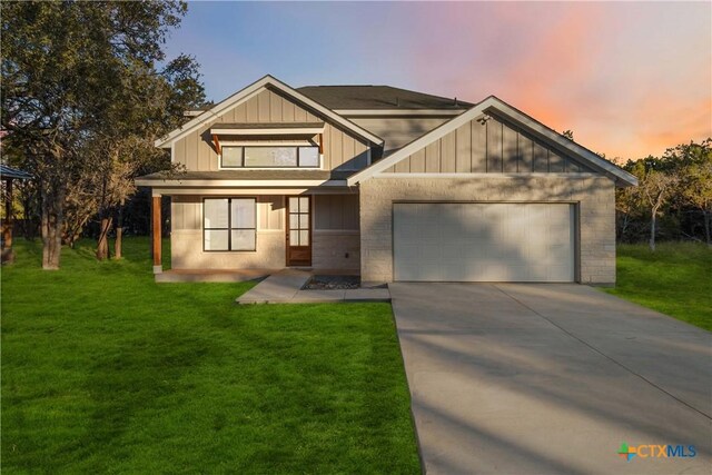 view of front of home featuring concrete driveway, a front lawn, board and batten siding, and an attached garage