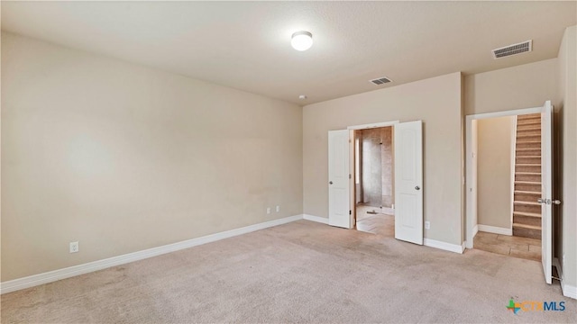 unfurnished bedroom with light colored carpet