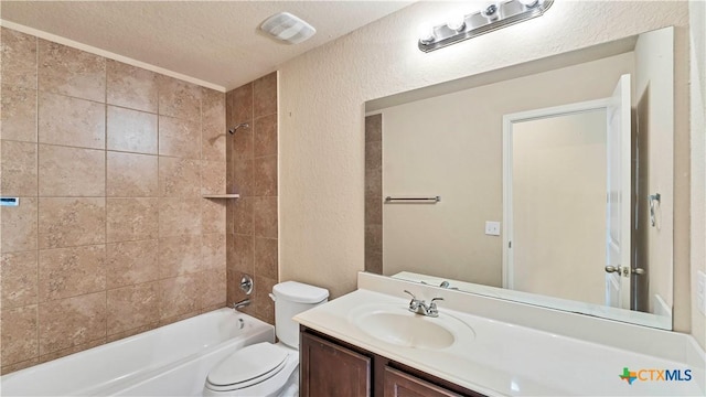 full bathroom with vanity, toilet, a textured ceiling, and tiled shower / bath