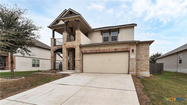 view of front of property featuring a garage, a balcony, and a front yard