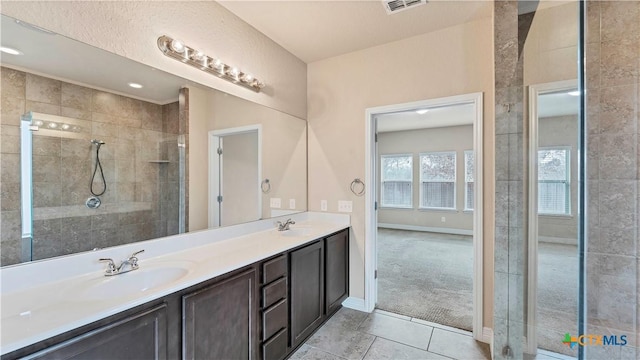 bathroom with tile patterned floors, vanity, and walk in shower