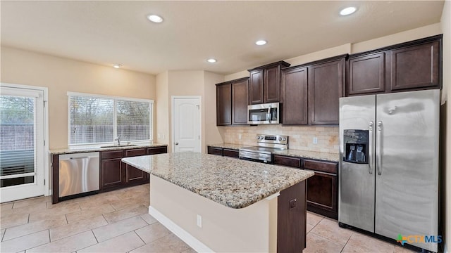 kitchen featuring a center island, a healthy amount of sunlight, sink, and appliances with stainless steel finishes