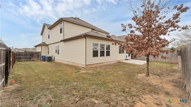 rear view of property with central AC, a yard, and a patio