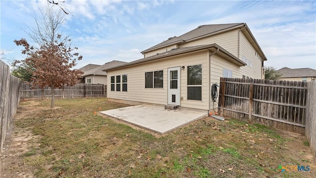 back of house featuring a patio area and a yard