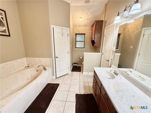 bathroom featuring tile patterned flooring, vanity, a bath, and toilet