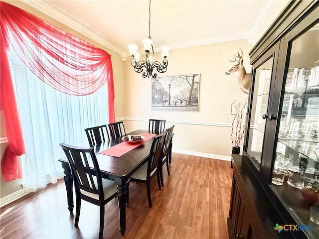 dining space featuring hardwood / wood-style floors, ornamental molding, french doors, and a chandelier