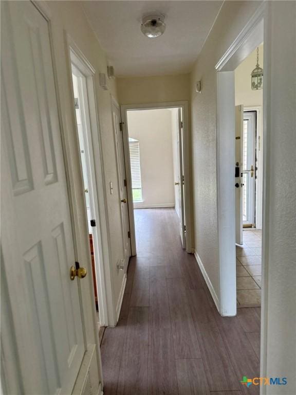 hall with baseboards and dark wood finished floors