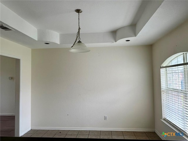 tiled empty room featuring baseboards and visible vents