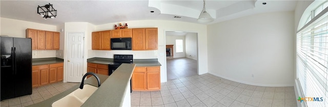 kitchen with baseboards, a sink, black appliances, and plenty of natural light