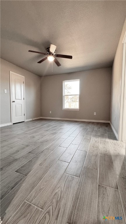 spare room with ceiling fan, light hardwood / wood-style flooring, and a textured ceiling