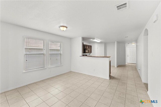 1032 Sandwell Ct, Seguin, TX 78155 - unfurnished living room with baseboards, visible vents, and light tile patterned floors