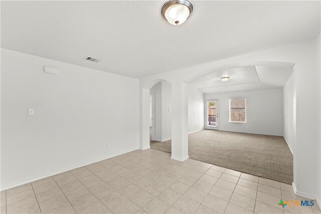 1032 Sandwell Ct, Seguin, TX 78155 - spare room with arched walkways, visible vents, light tile patterned floors, and light carpet