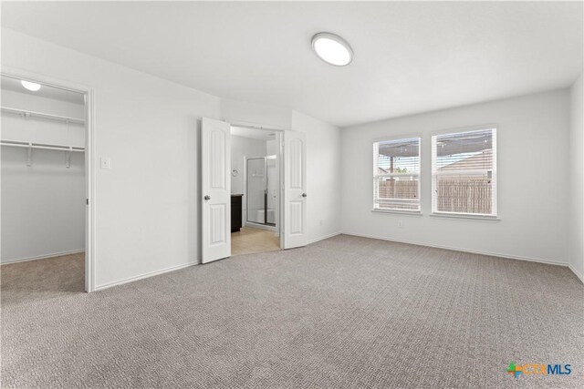 1032 Sandwell Ct, Seguin, TX 78155 - unfurnished bedroom with light colored carpet, a closet, baseboards, and a spacious closet