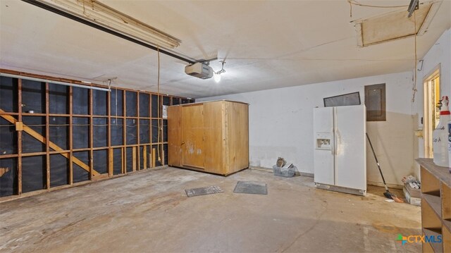 garage featuring a garage door opener, white refrigerator with ice dispenser, and electric panel