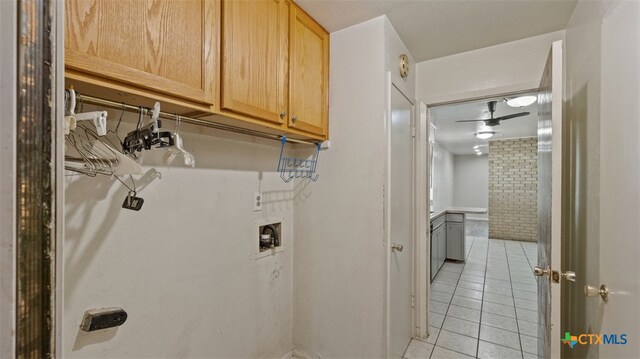 washroom featuring hookup for a washing machine, cabinet space, and light tile patterned floors