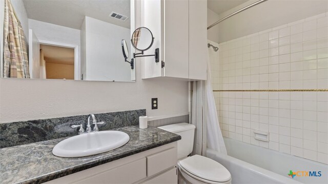 bathroom featuring shower / tub combo with curtain, vanity, toilet, and visible vents