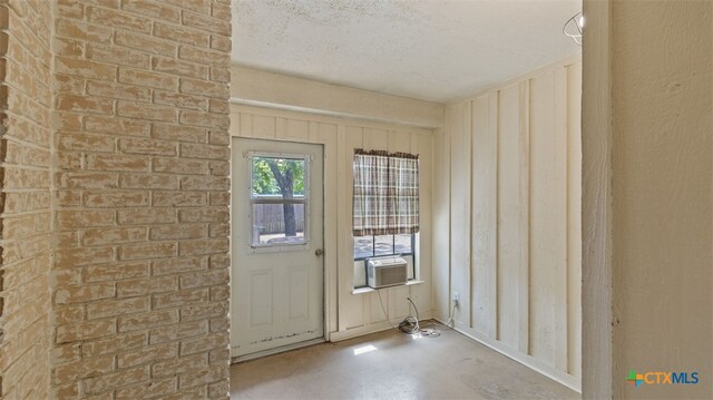 entryway featuring a textured ceiling, cooling unit, and finished concrete floors