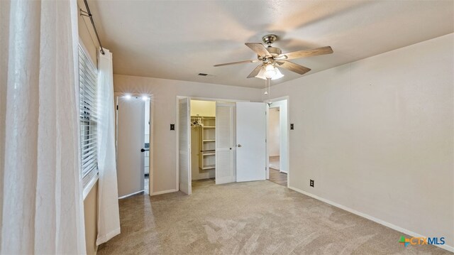 unfurnished bedroom featuring baseboards, carpet, a ceiling fan, and visible vents