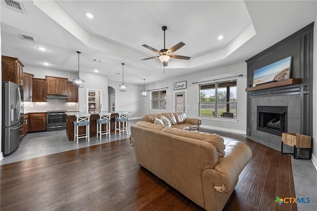 3631 Morgan Mill Rd, Kempner, TX 76539 - living room with a raised ceiling, ceiling fan, dark wood-style floors, a tile fireplace, and recessed lighting