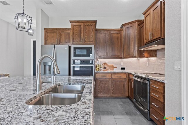 3631 Morgan Mill Rd, Kempner, TX 76539 - kitchen featuring stainless steel appliances, under cabinet range hood, tasteful backsplash, and light stone countertops