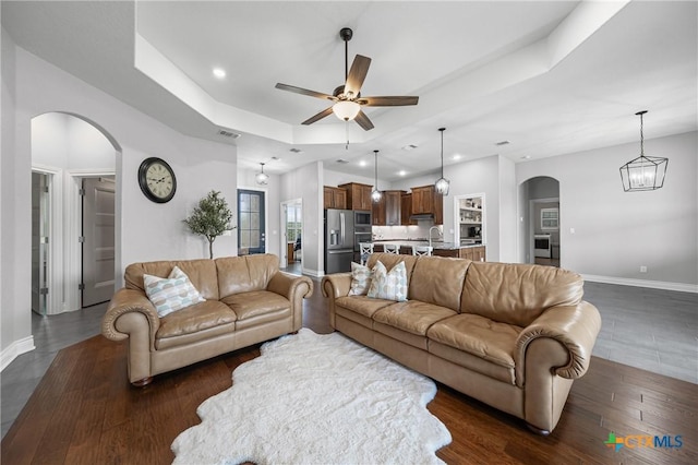 3631 Morgan Mill Rd, Kempner, TX 76539 - living room with arched walkways, recessed lighting, a raised ceiling, a ceiling fan, and dark wood-style flooring