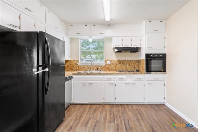 2410 Meadow Ln, Copperas Cove, TX 76522 - kitchen featuring black appliances, under cabinet range hood, light wood-type flooring, white cabinets, and light stone countertops