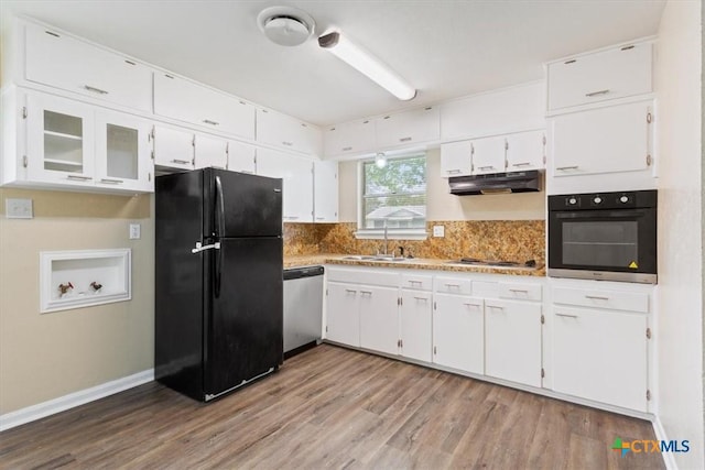 2410 Meadow Ln, Copperas Cove, TX 76522 - kitchen featuring black appliances, under cabinet range hood, white cabinetry, wood finished floors, and decorative backsplash