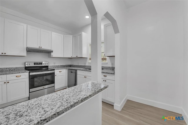 51 Private Road 901, Florence, TX 76527 - kitchen with appliances with stainless steel finishes, light wood finished floors, light stone countertops, white cabinets, and under cabinet range hood