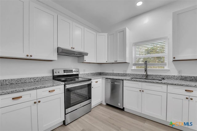 51 Private Road 901, Florence, TX 76527 - kitchen with stainless steel appliances, under cabinet range hood, light wood finished floors, white cabinets, and recessed lighting