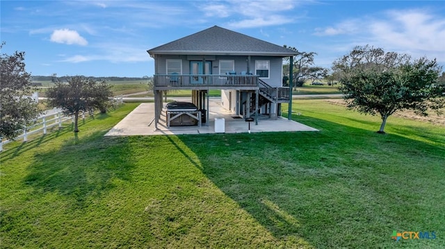 back of property with a wooden deck, a patio area, and a lawn