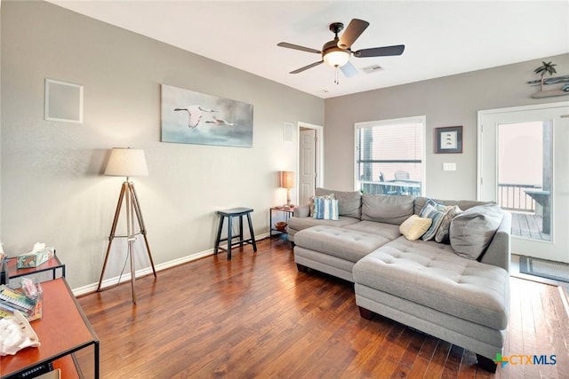 living room with ceiling fan and dark wood-type flooring