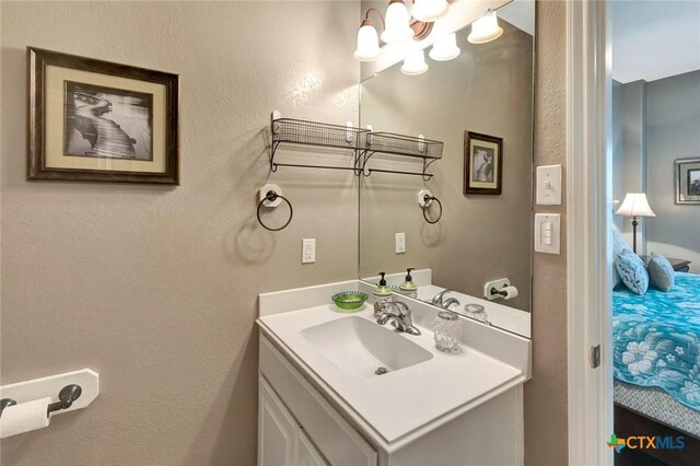 314 Windswept Dr, Port Lavaca, TX 77979 - bathroom with vanity, a textured wall, and connected bathroom