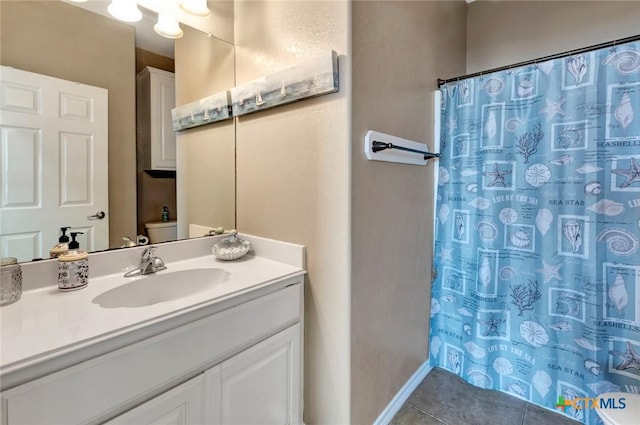 bathroom with tile patterned flooring, vanity, toilet, and walk in shower