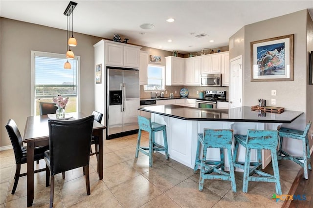 314 Windswept Dr, Port Lavaca, TX 77979 - kitchen featuring appliances with stainless steel finishes, dark countertops, a peninsula, backsplash, and a kitchen bar