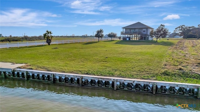 view of dock featuring a lawn, a water view, and a rural view