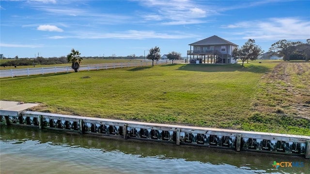 exterior space featuring a rural view, a yard, and a deck with water view