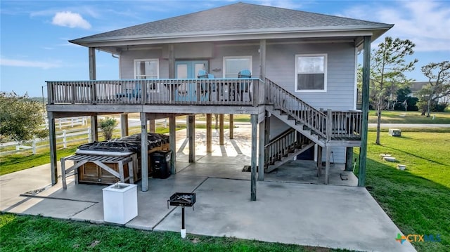 rear view of property featuring a patio, a deck, and a lawn