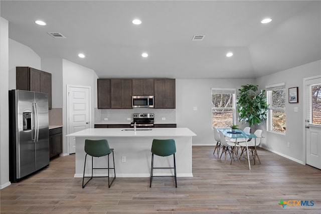 kitchen featuring tasteful backsplash, visible vents, appliances with stainless steel finishes, and light countertops