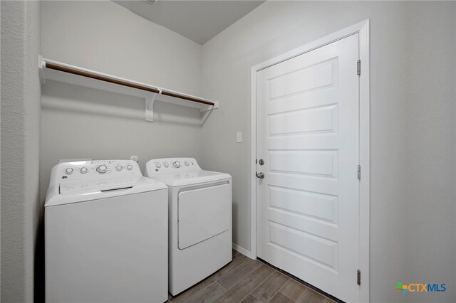 washroom with baseboards, laundry area, washing machine and clothes dryer, and wood tiled floor