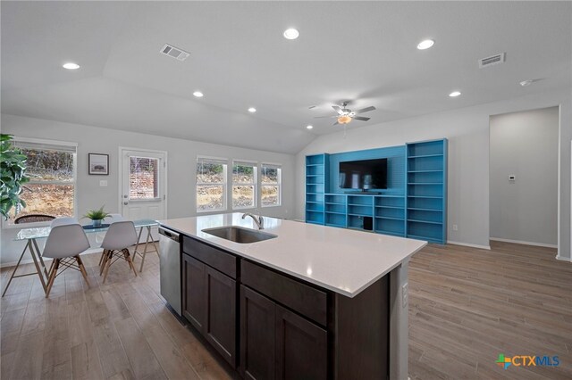 kitchen featuring light countertops, visible vents, light wood-style floors, a sink, and dishwasher