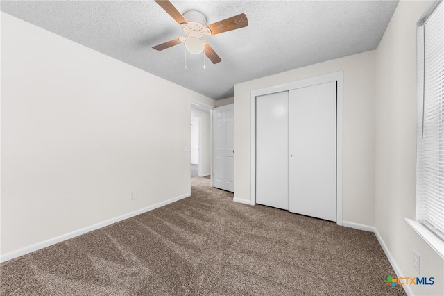 unfurnished bedroom featuring a closet, a textured ceiling, ceiling fan, and carpet floors