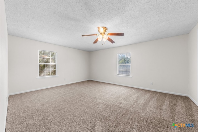 carpeted empty room featuring ceiling fan and a textured ceiling