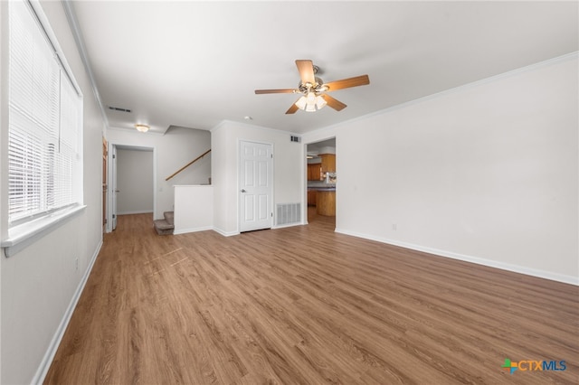 unfurnished living room with ceiling fan, ornamental molding, and light hardwood / wood-style flooring