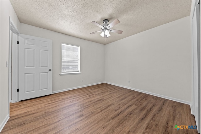 empty room with wood-type flooring, ceiling fan, and a textured ceiling