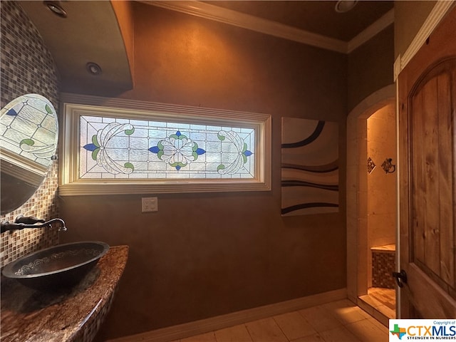 bathroom featuring tile patterned floors, sink, and crown molding